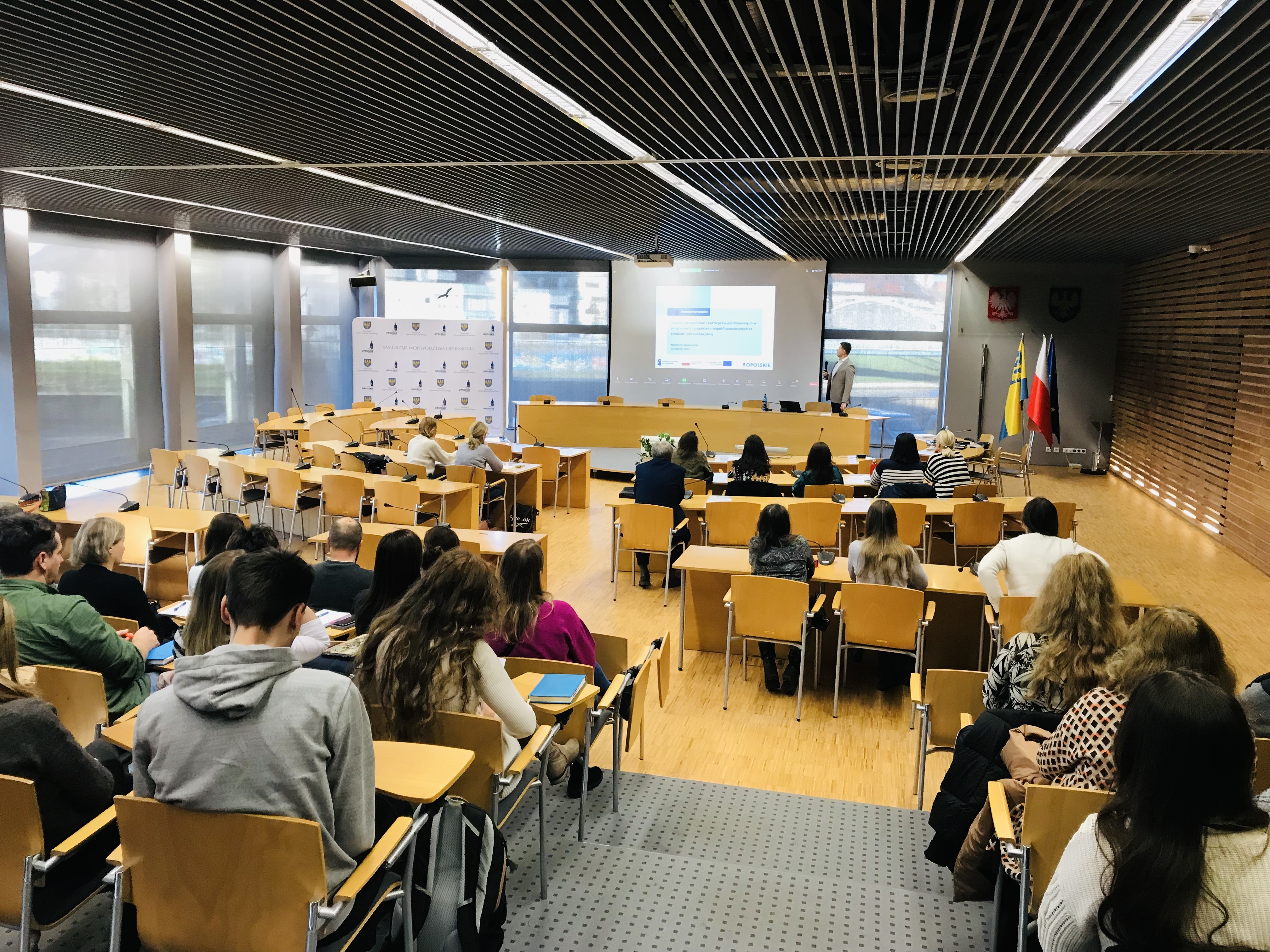 Zdjęcie przedstawia salę szkoleniową z zasad równościowych i Karty praw podstawowych w ramach programu regionalnego Fundusze Europejskie dla Opolskiego w 2024 r. wraz z uczestnikami i trenerem podczas szkolenia specjalistycznego